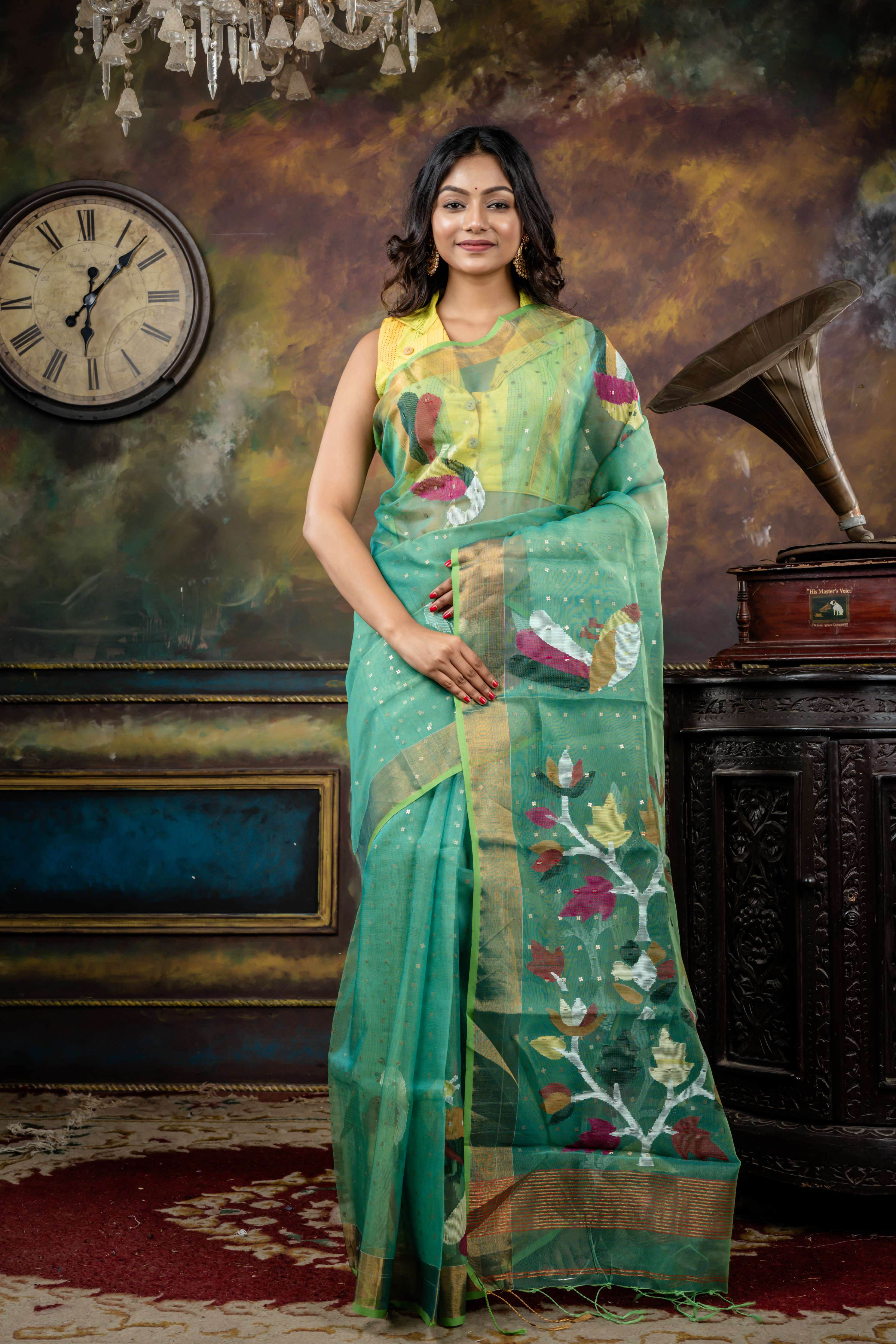 Vasuda || Parrot Green & Teal Green dual tone Premium Muslin Bengal Handloom Saree with all over woven Antique Gold Sequins, Multi-colour 'Peacock' motif & Antique Gold Zari Border and Floral Jamdani Pallu