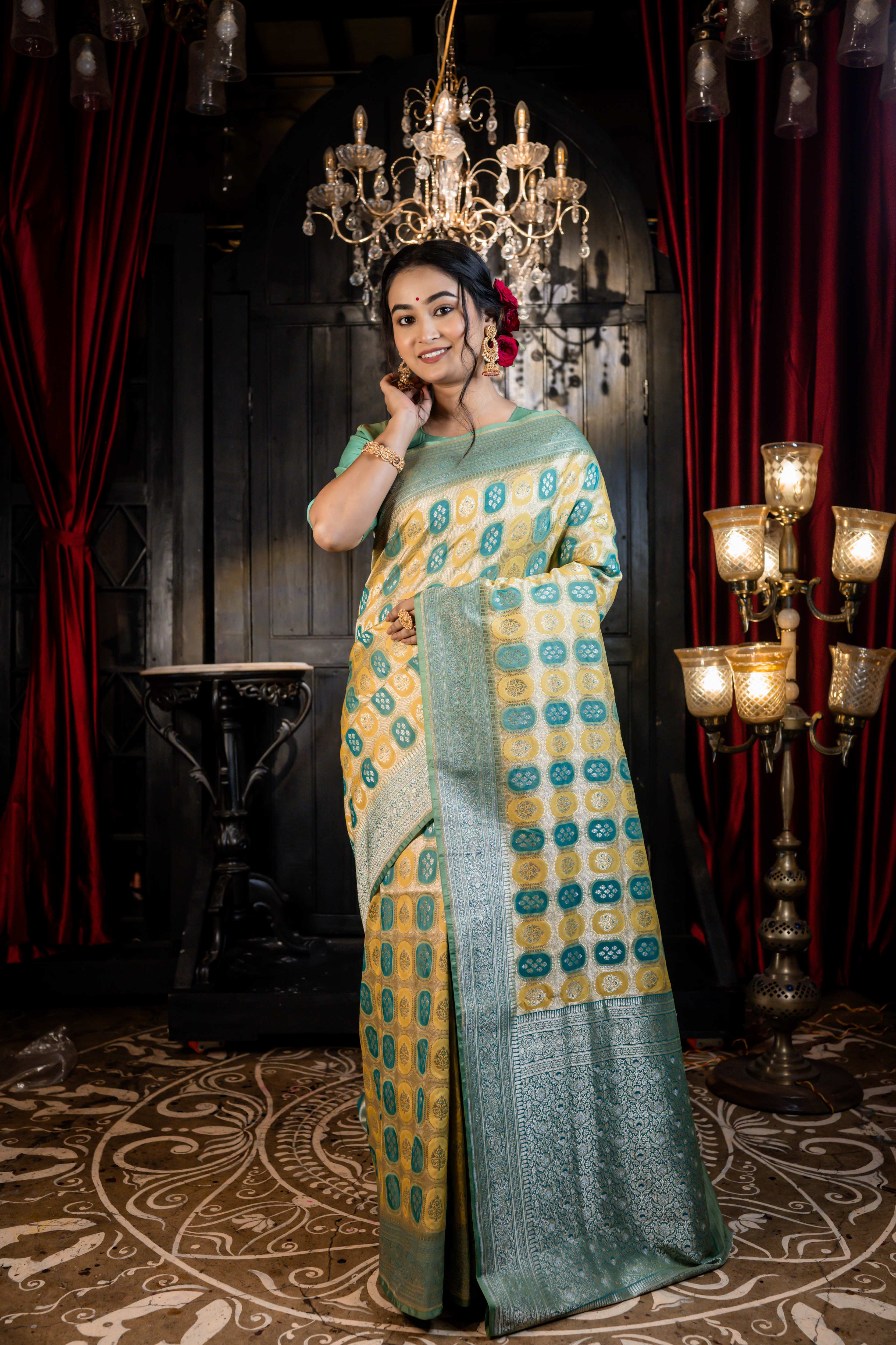 Vanaja || Woven Matte Gold Zari base Matka Silk Banarasi Saree with all over Teal & Olive Green Capsule shape Buta and Meenakari Floral highlights