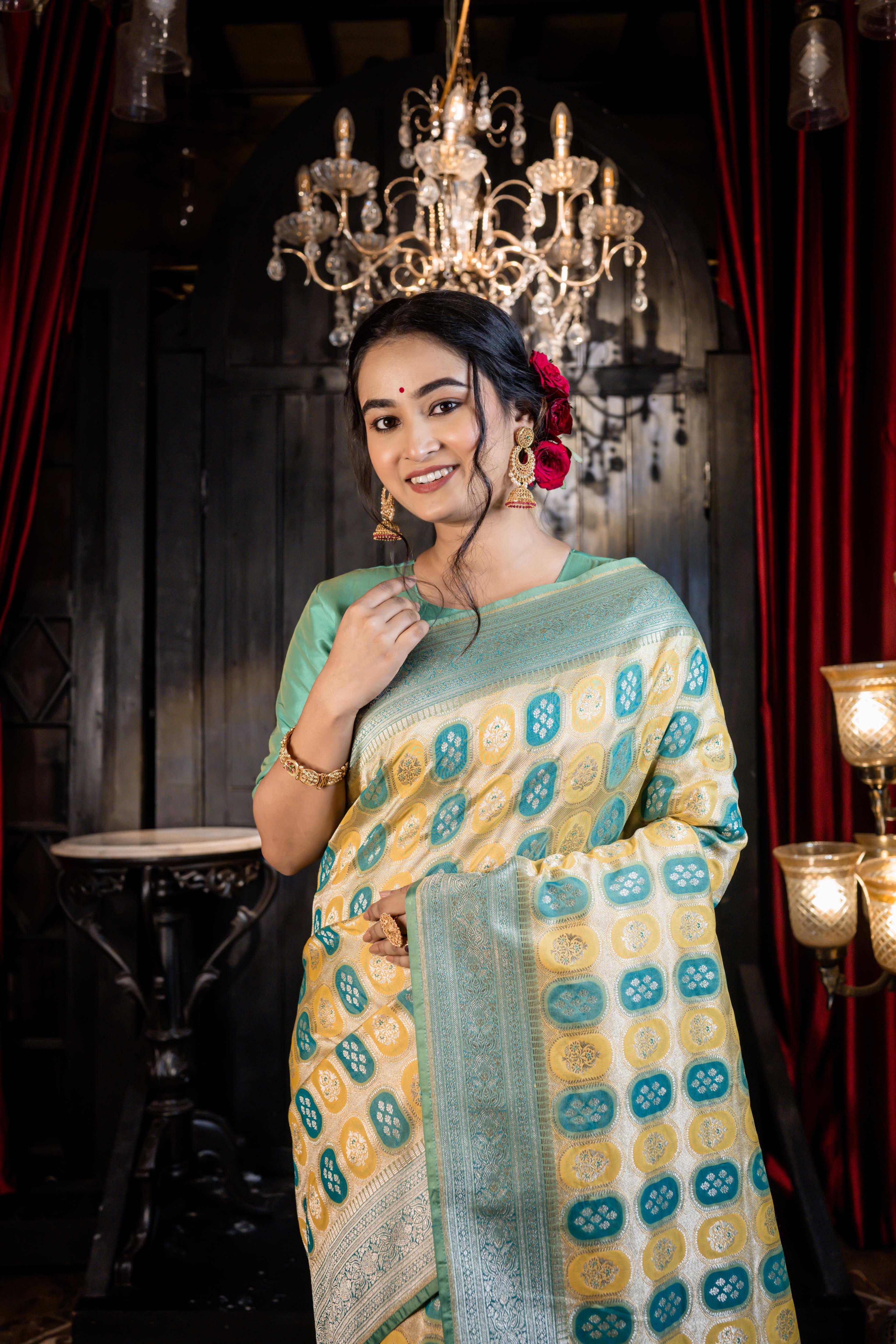 Vanaja || Woven Matte Gold Zari base Matka Silk Banarasi Saree with all over Teal & Olive Green Capsule shape Buta and Meenakari Floral highlights