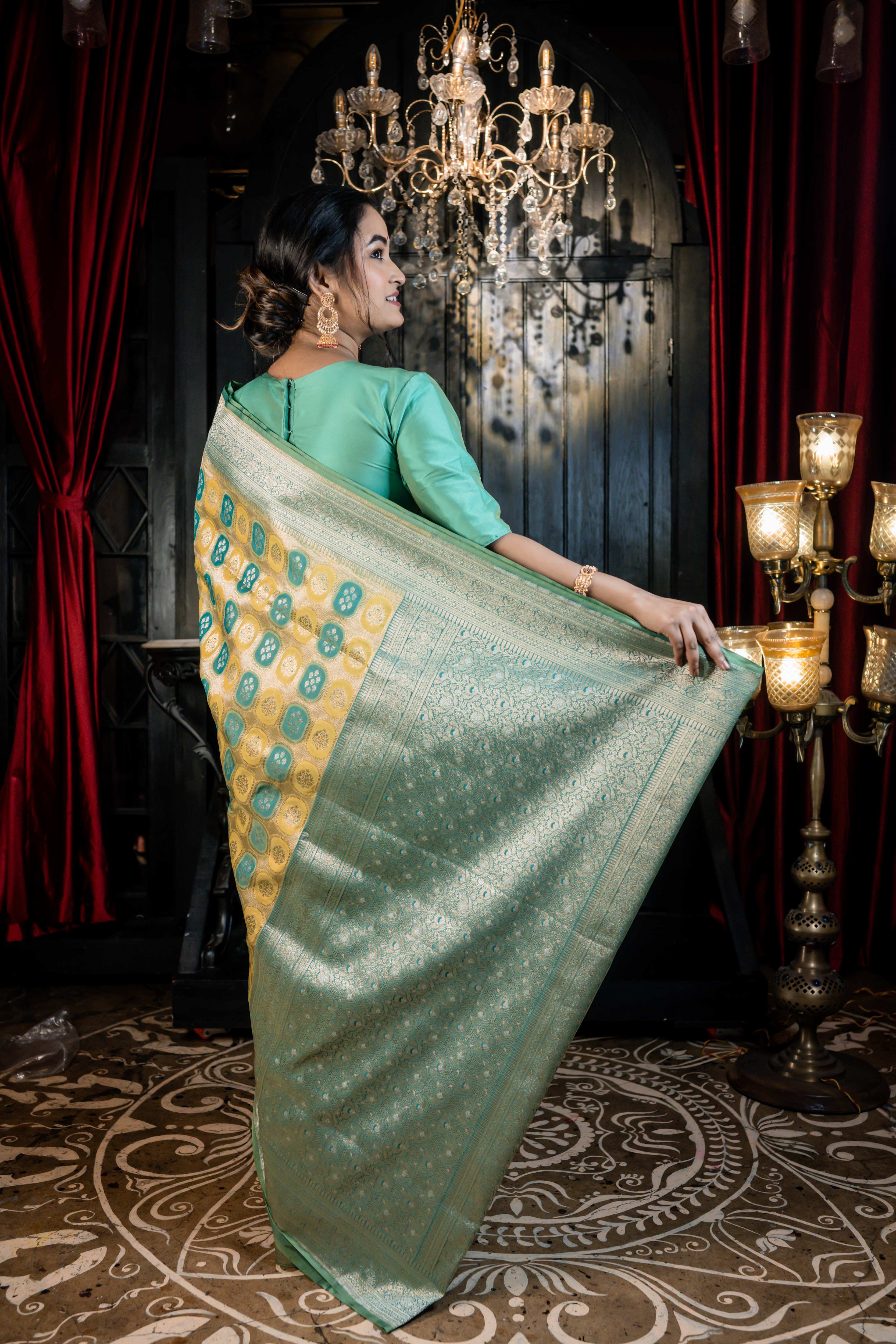 Vanaja || Woven Matte Gold Zari base Matka Silk Banarasi Saree with all over Teal & Olive Green Capsule shape Buta and Meenakari Floral highlights