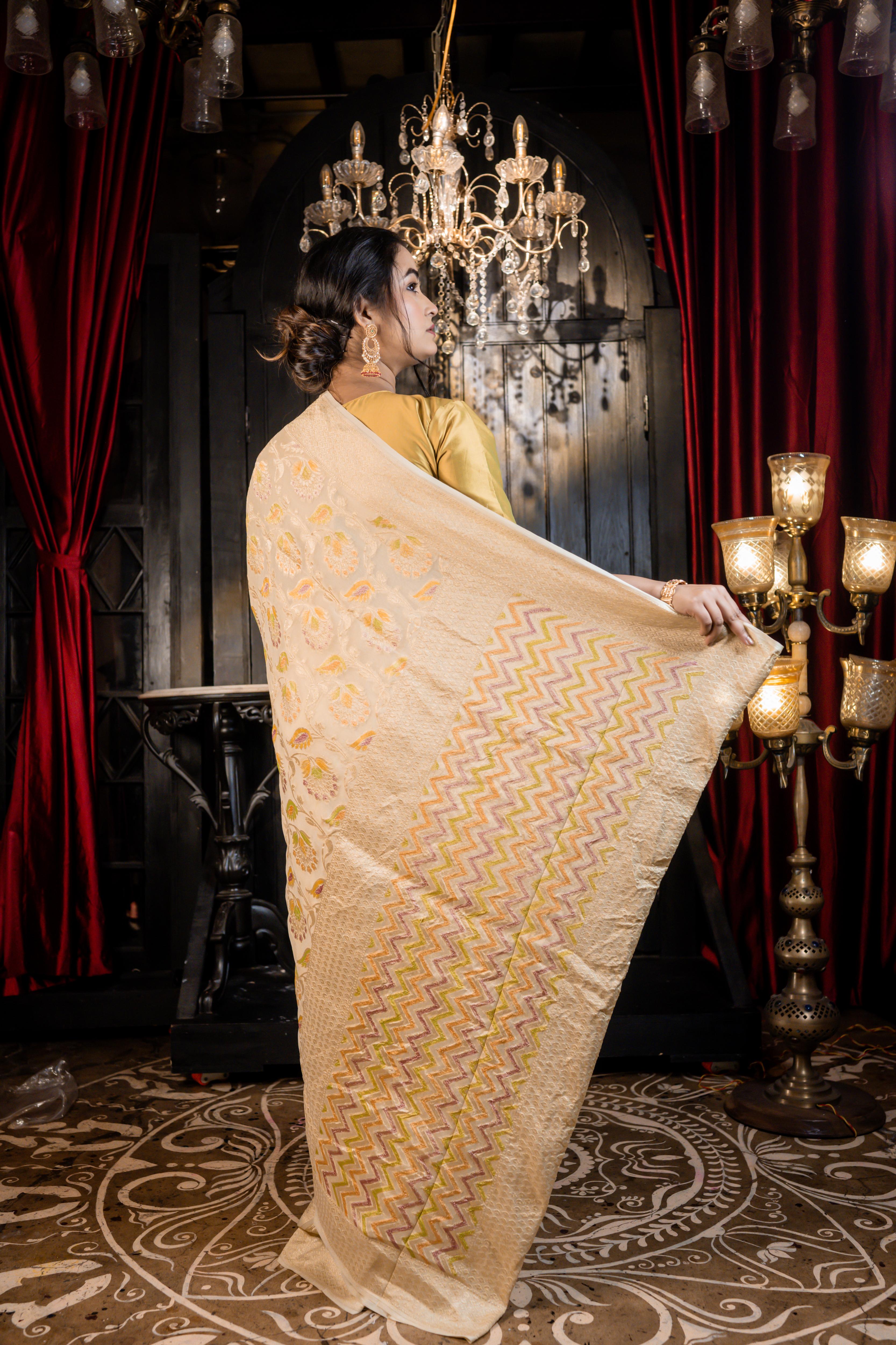 Iva || Ivory Khaddi Georgette Banarasi Saree with all over Rifling Handbrush Multi-colour & Matte Gold Zari Floral motif Jangla