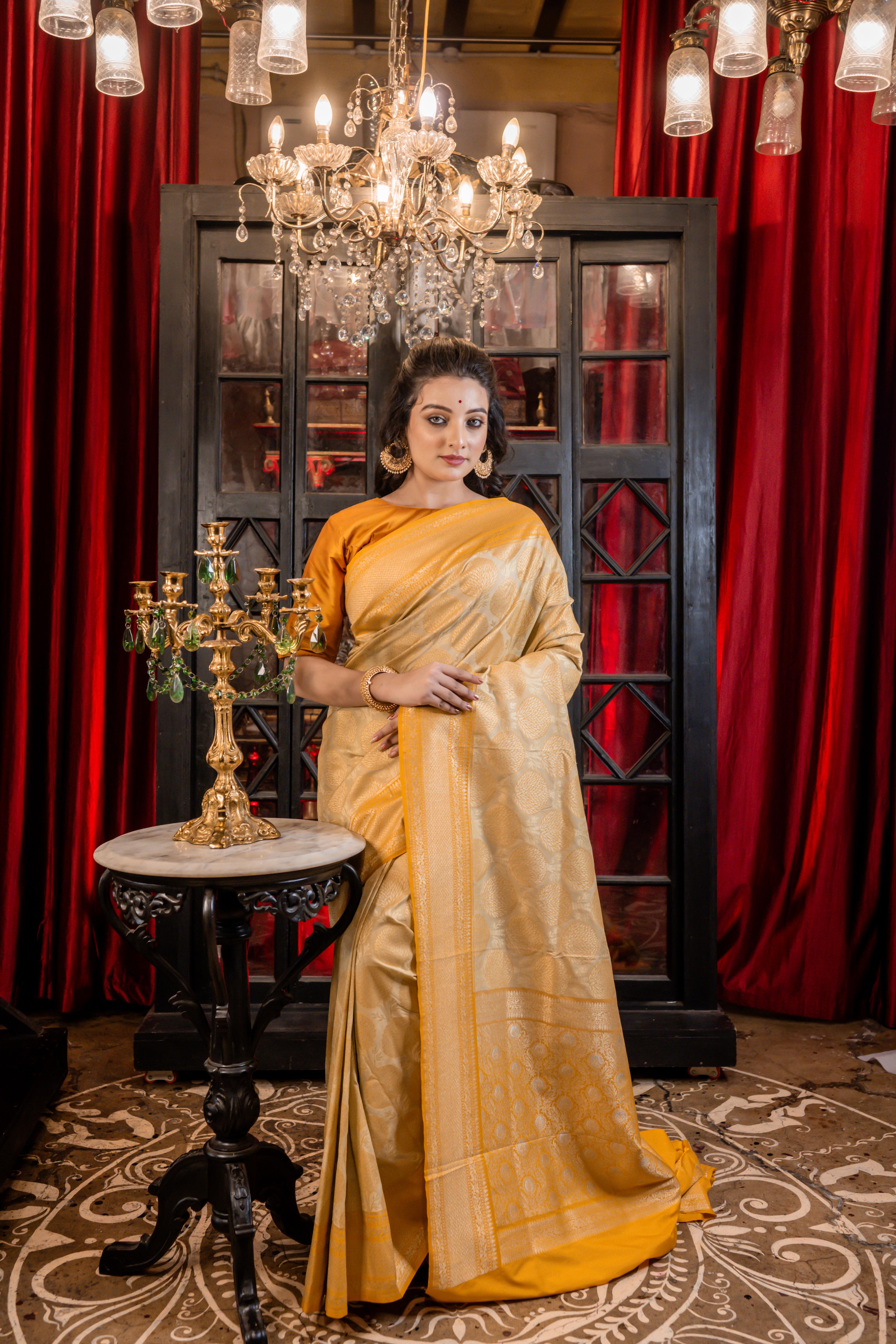 Varnika || Beige Base Matka Silk Banarasi Saree with Mango Yellow border and all over Tree motif woven in Matte Gold Zari