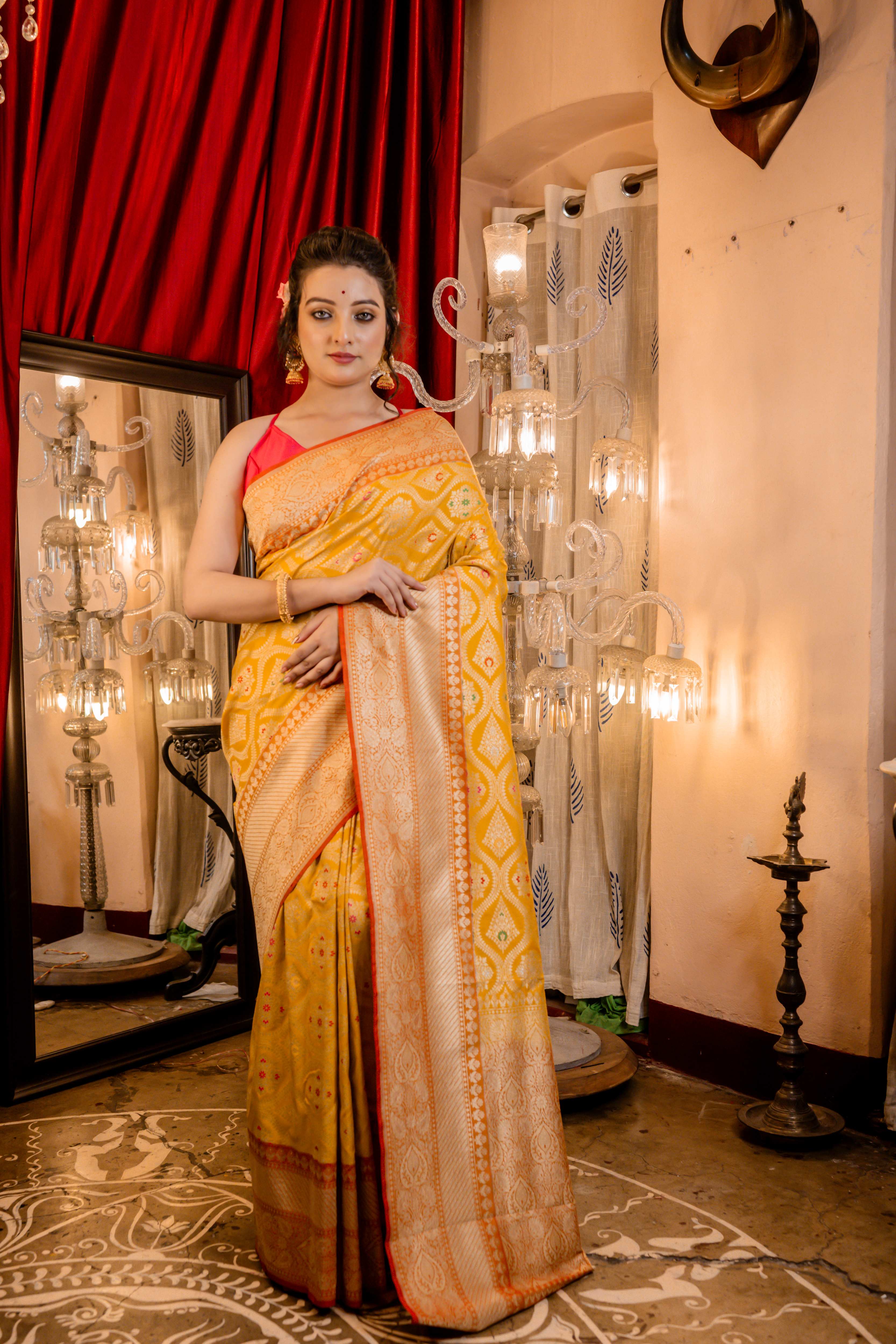Ravina || Turmeric Yellow Matka Silk Banarasi Saree with Pale Orange border, all over Floral Jaal woven in Matte Gold Zari and multi-colour Meenakari highlights