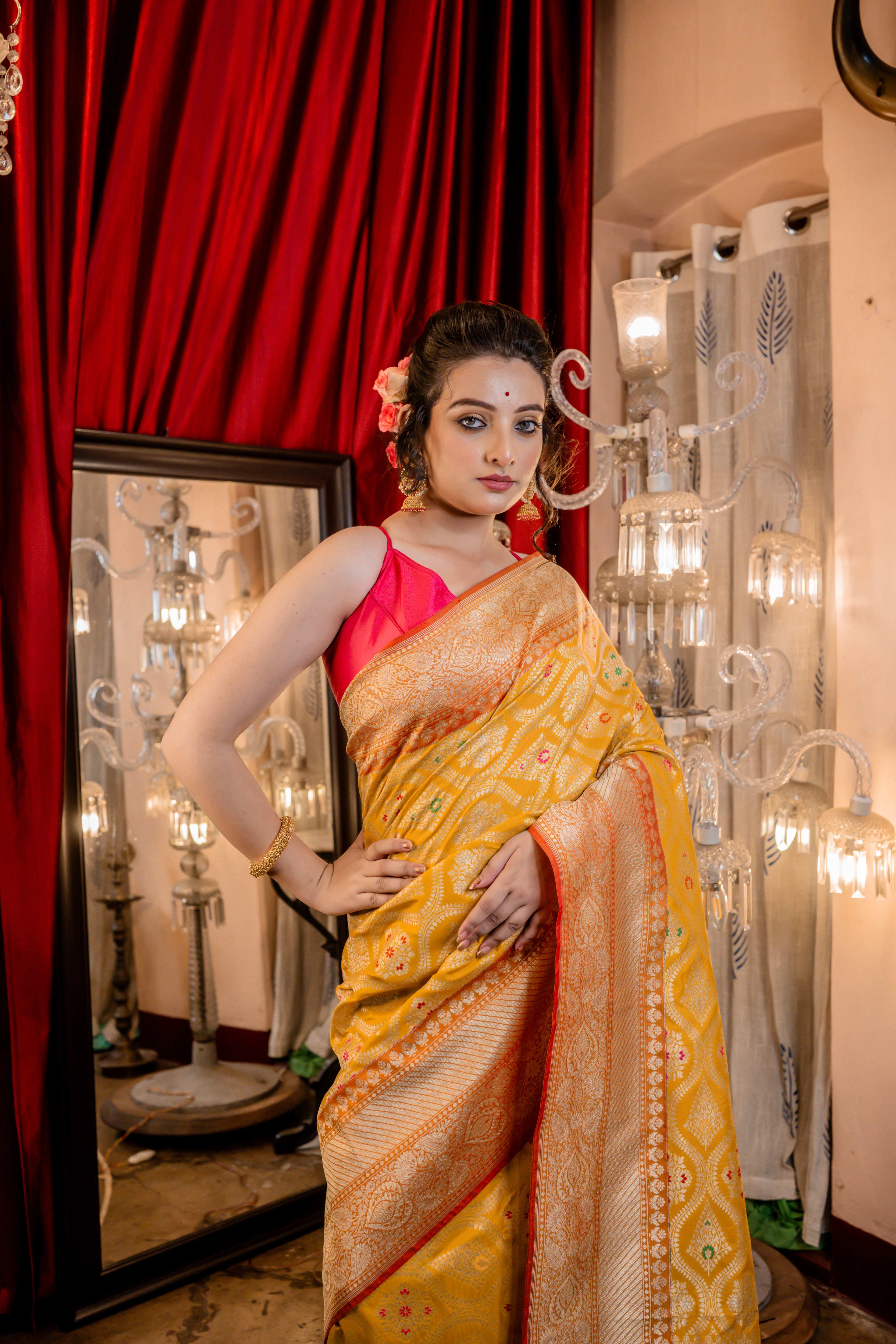 Ravina || Turmeric Yellow Matka Silk Banarasi Saree with Pale Orange border, all over Floral Jaal woven in Matte Gold Zari and multi-colour Meenakari highlights