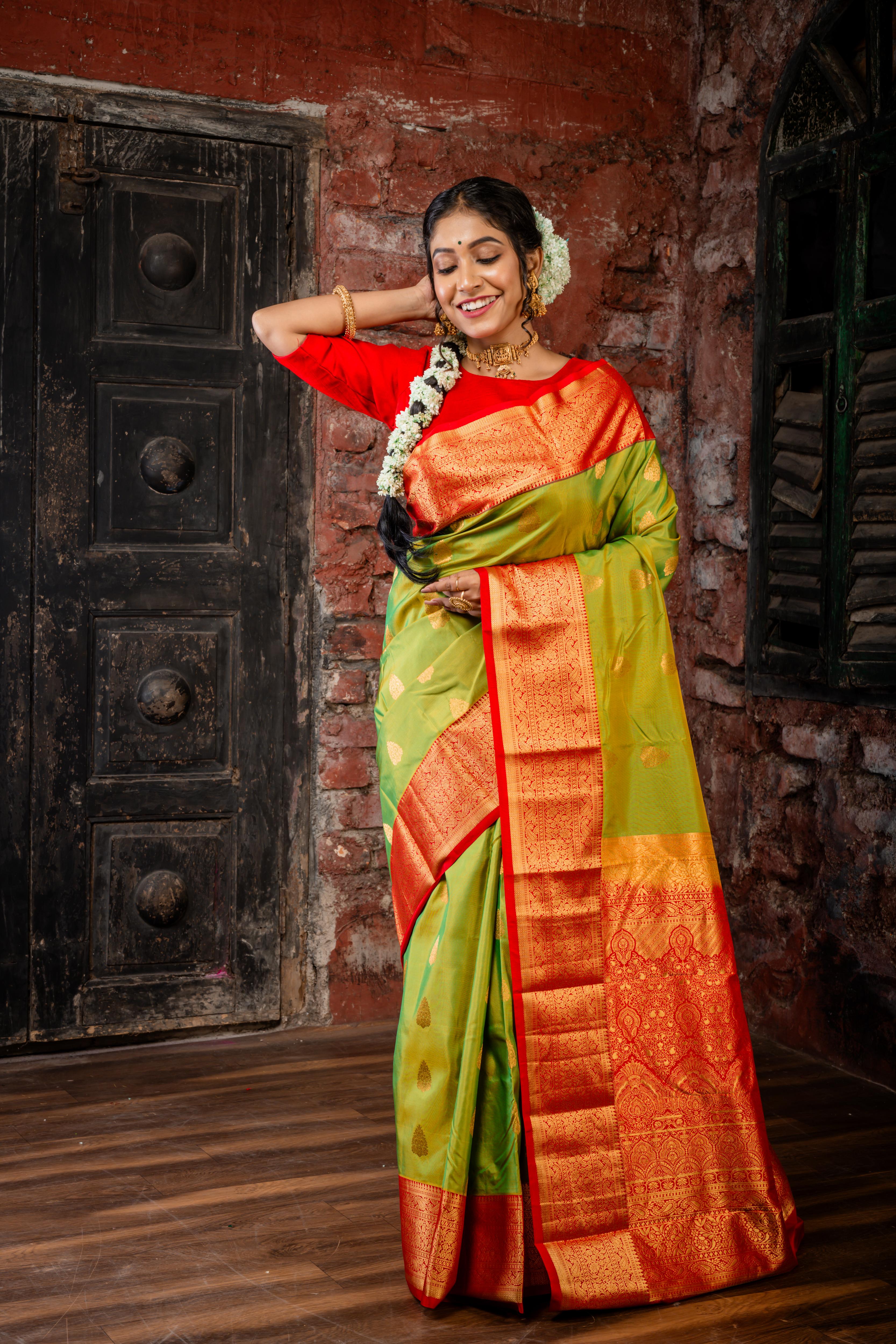 Laajvanthi || Olive Green & Mustard Yellow dual tone Pure Kanjivaram Silk Handloom Saree with all over Golden Zari traditional Buta, Red broad & Golden Zari Border and traditional design Pallu