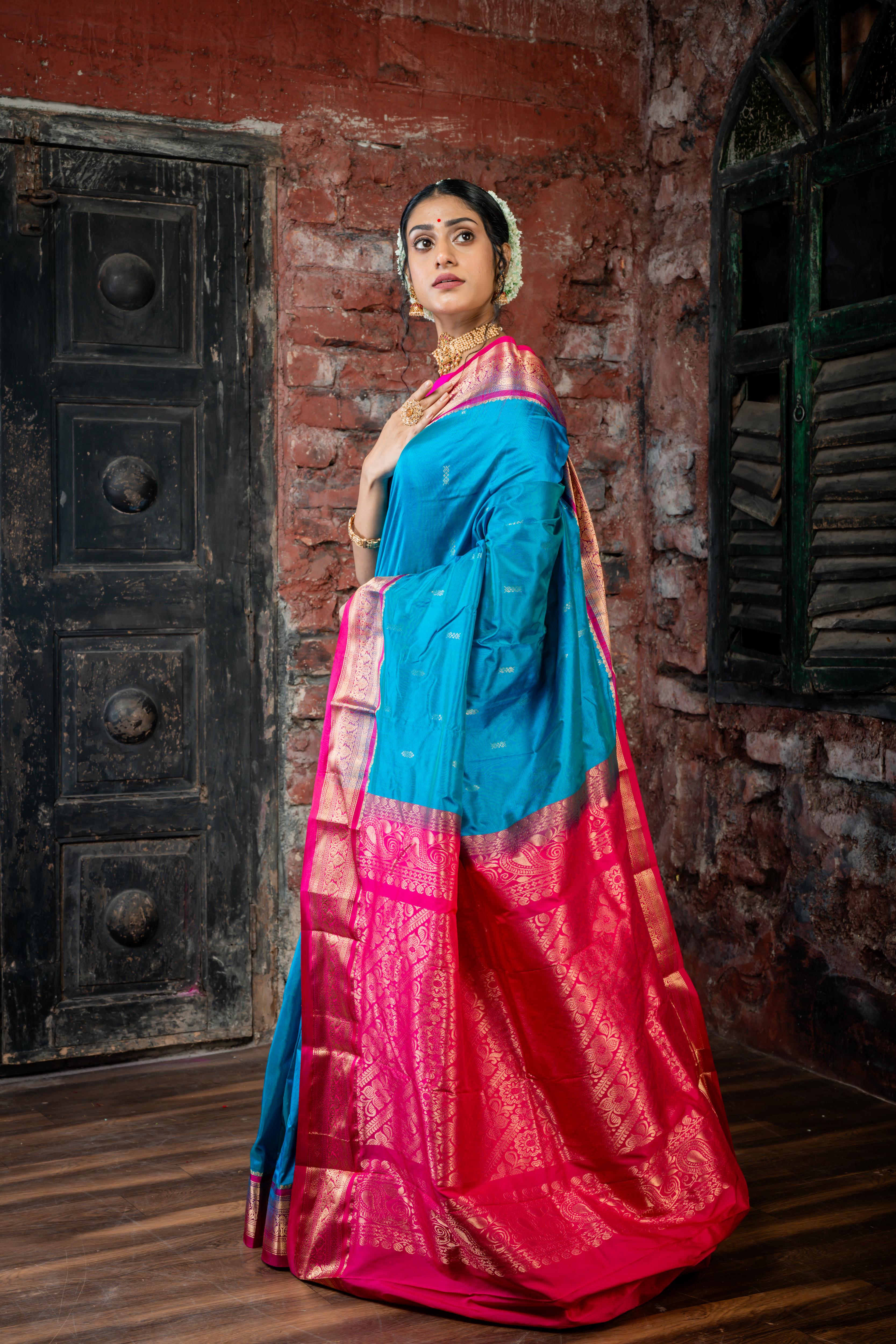 Neelavati || Bright Cyan Blue Kanjivaram Silk Saree with all over Matte Gold Zari Buta, Magenta & Matte Gold Zari Border and Magenta Pallu in Matte Gold Zari Traditional 'Kalka' & Floral design