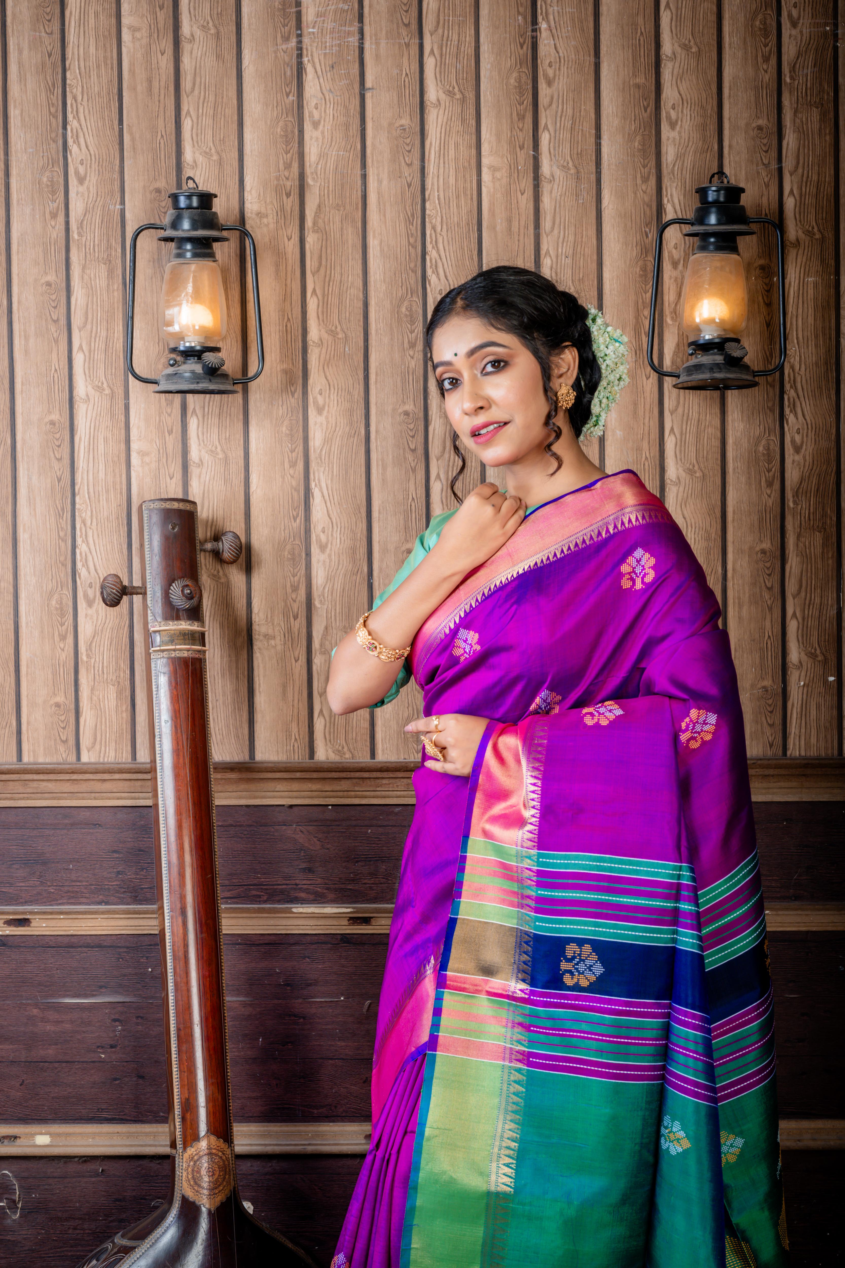 Pritha || Purple & Royal Blue dual tone Pure Bishnupuri Katan Handloom 'Kalakshetra' Embroidery Saree with all over Multi-colour Floral Buta and Stripe & 'Peacock' motif Green Pallu
