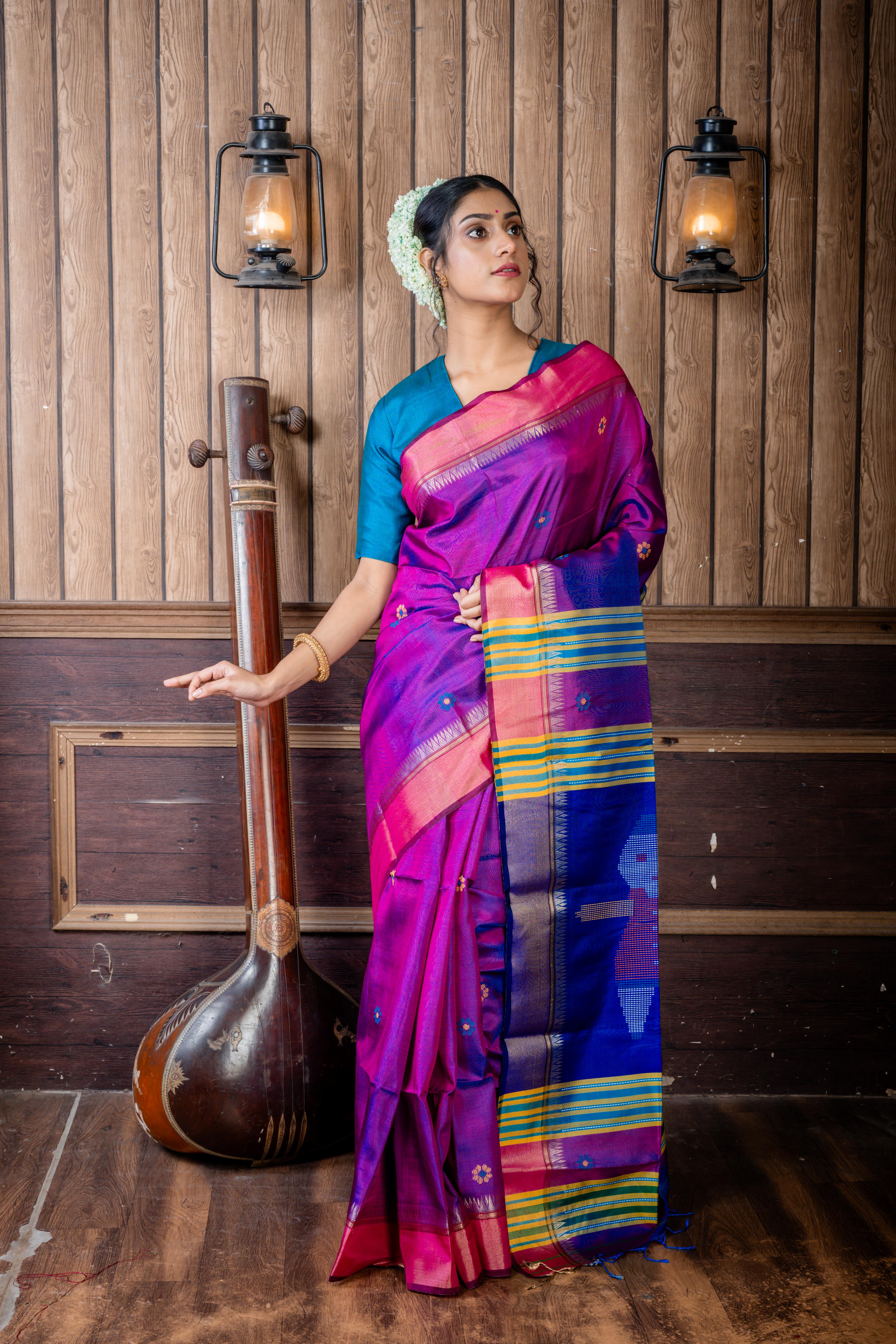 Dotara || Purple & Peacock Blue dual tone Pure Bishnupuri Katan Handloom 'Kalakshetra' Embroidery Saree with all over Multi-colour Floral Buta and Stripe & 'Tribal Doll' motif Pallu