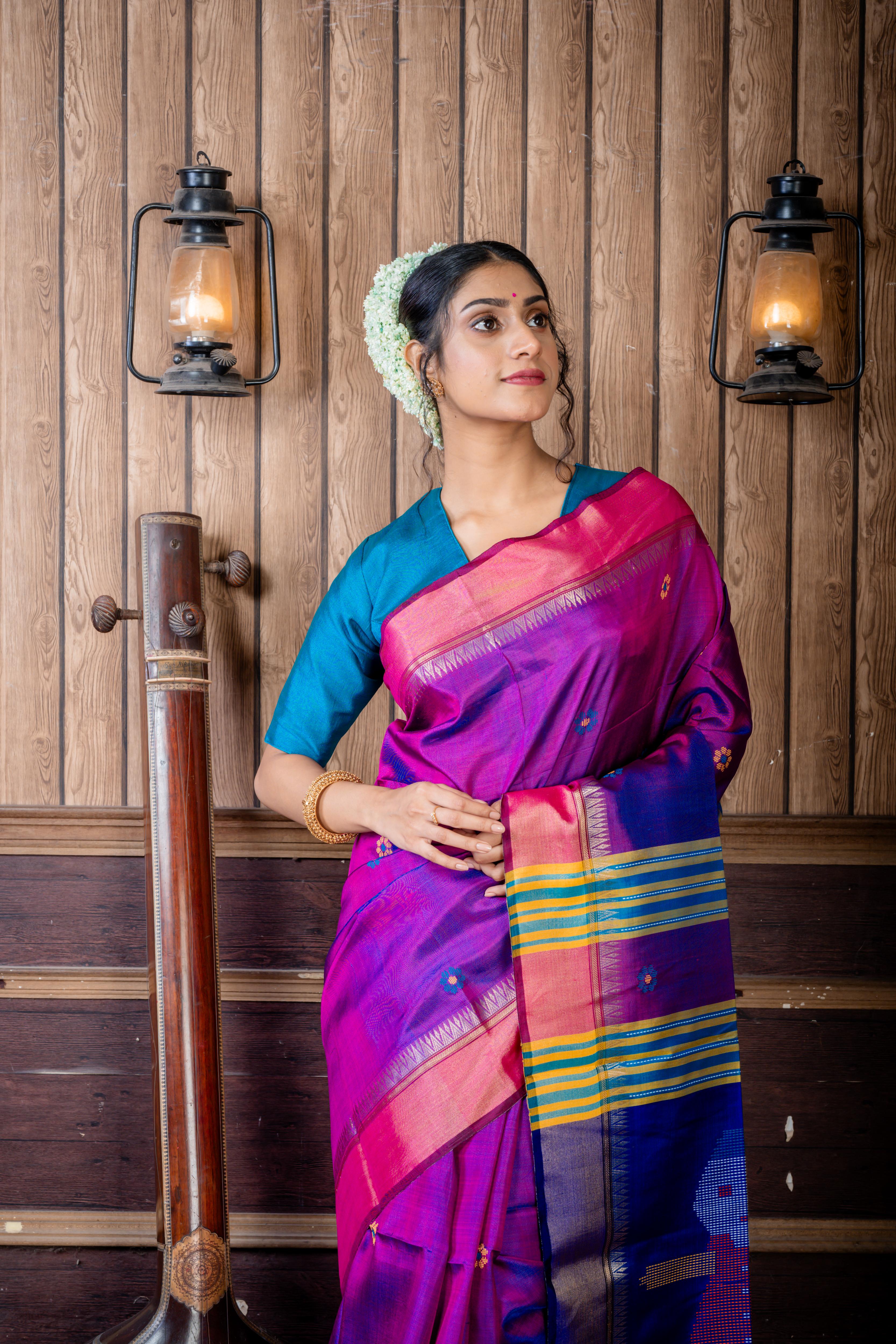Dotara || Purple & Peacock Blue dual tone Pure Bishnupuri Katan Handloom 'Kalakshetra' Embroidery Saree with all over Multi-colour Floral Buta and Stripe & 'Tribal Doll' motif Pallu