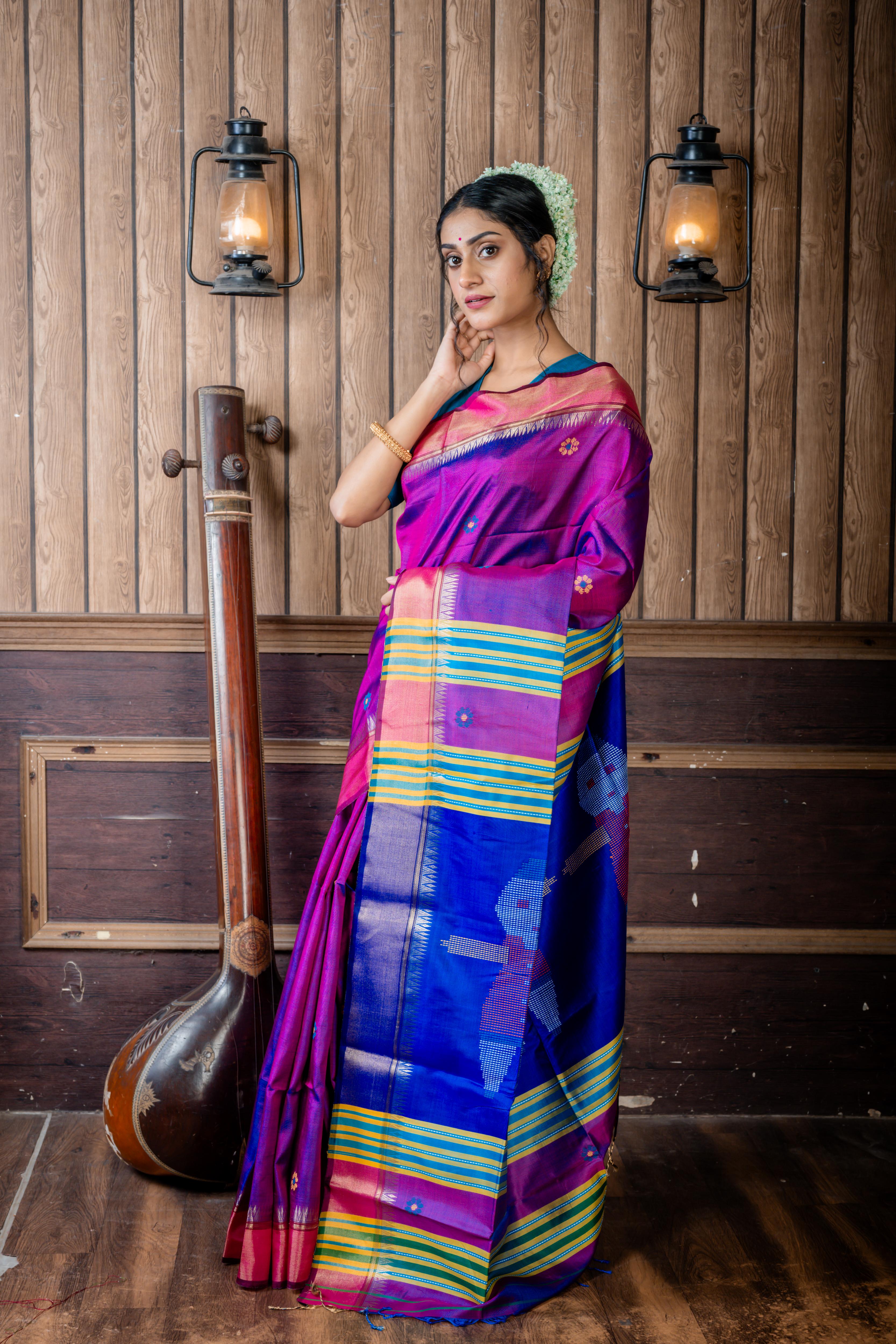 Dotara || Purple & Peacock Blue dual tone Pure Bishnupuri Katan Handloom 'Kalakshetra' Embroidery Saree with all over Multi-colour Floral Buta and Stripe & 'Tribal Doll' motif Pallu
