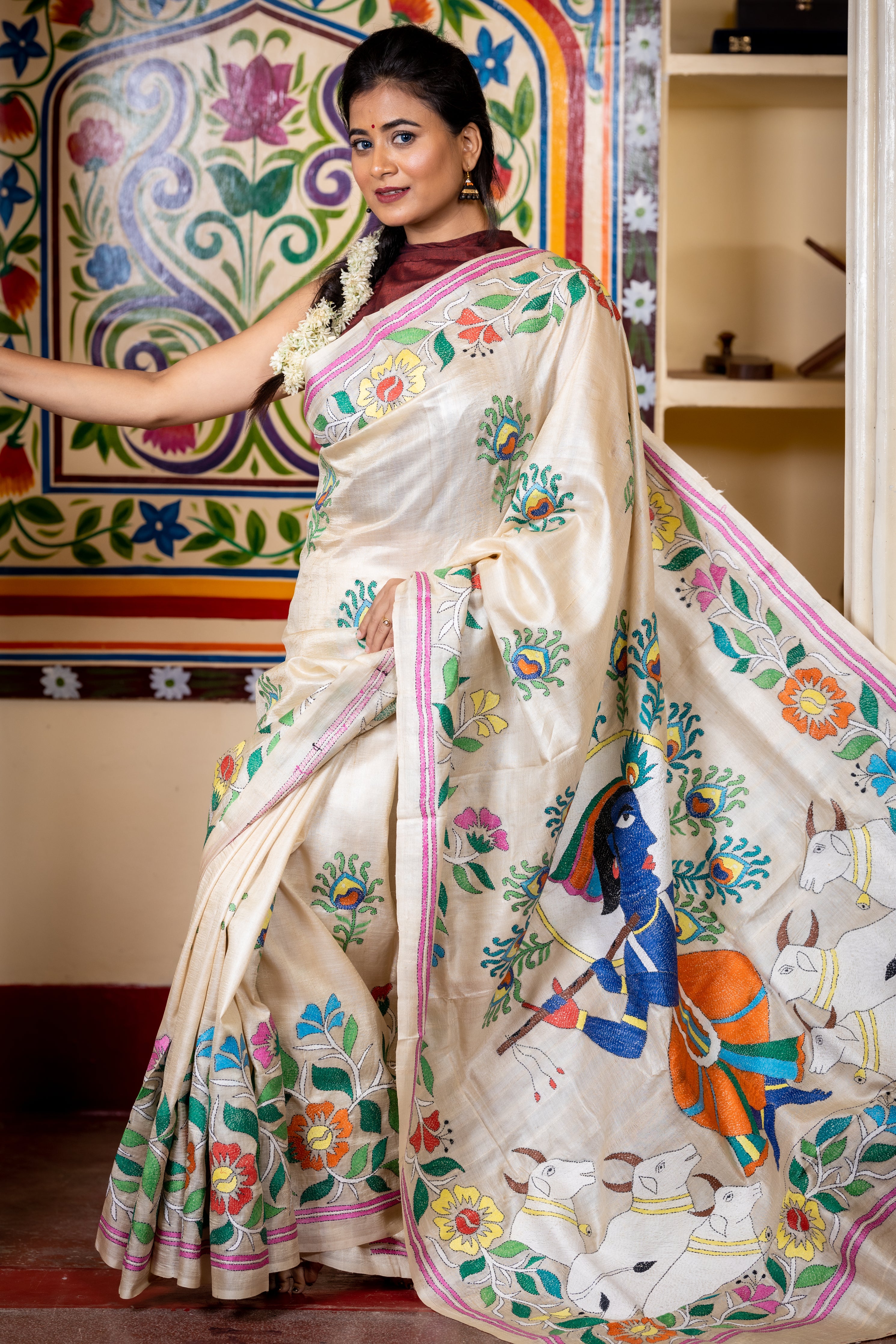 Brindabani || Beige Pure Gachhi Tussar Silk Handloom Kantha Stitch Embroidery Saree with all over Multi-colour 'Morpankh' motif Buta, Floral motif Border and 'Lord Krishna' theme Pallu