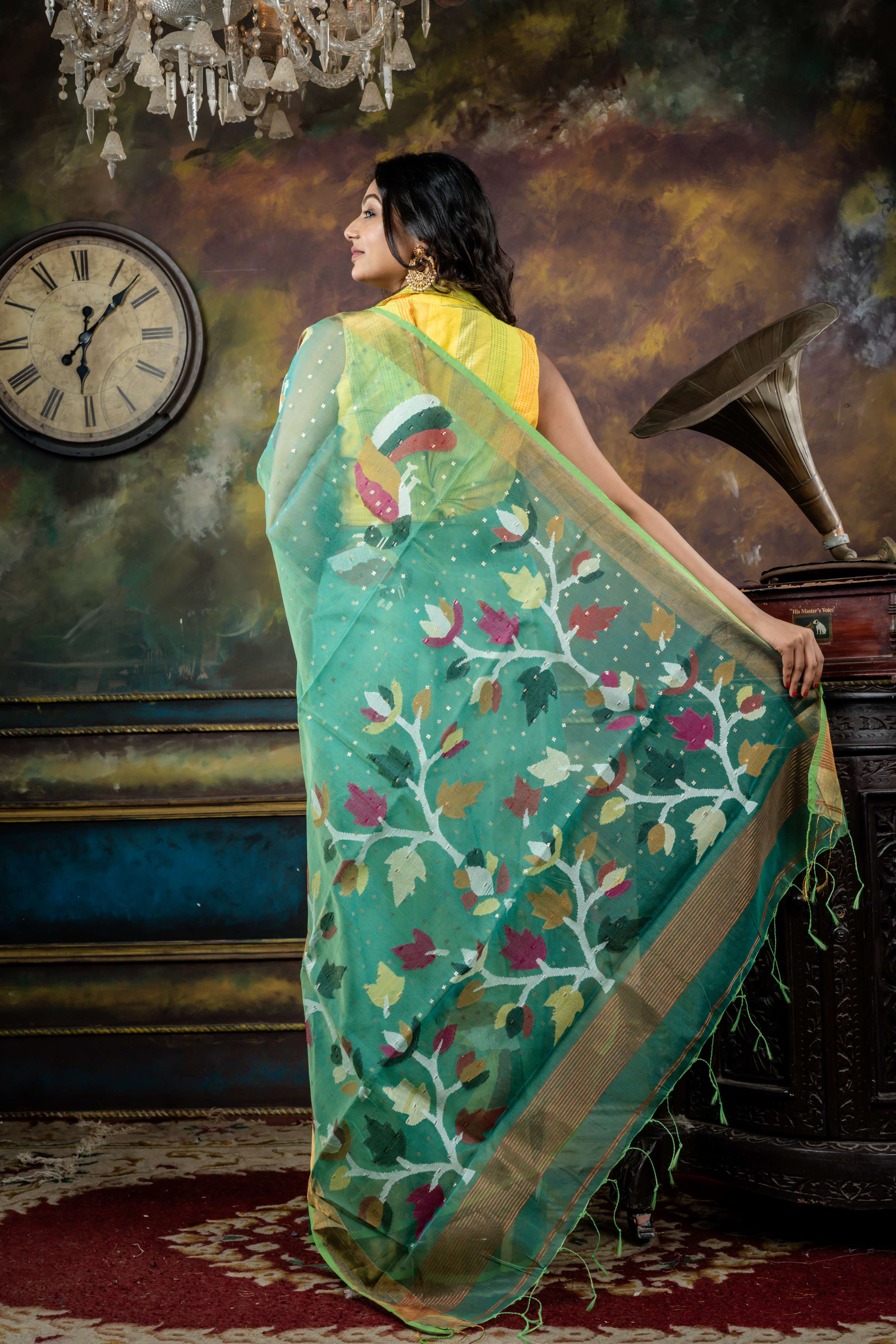 Vasuda || Parrot Green & Teal Green dual tone Premium Muslin Bengal Handloom Saree with all over woven Antique Gold Sequins, Multi-colour 'Peacock' motif & Antique Gold Zari Border and Floral Jamdani Pallu