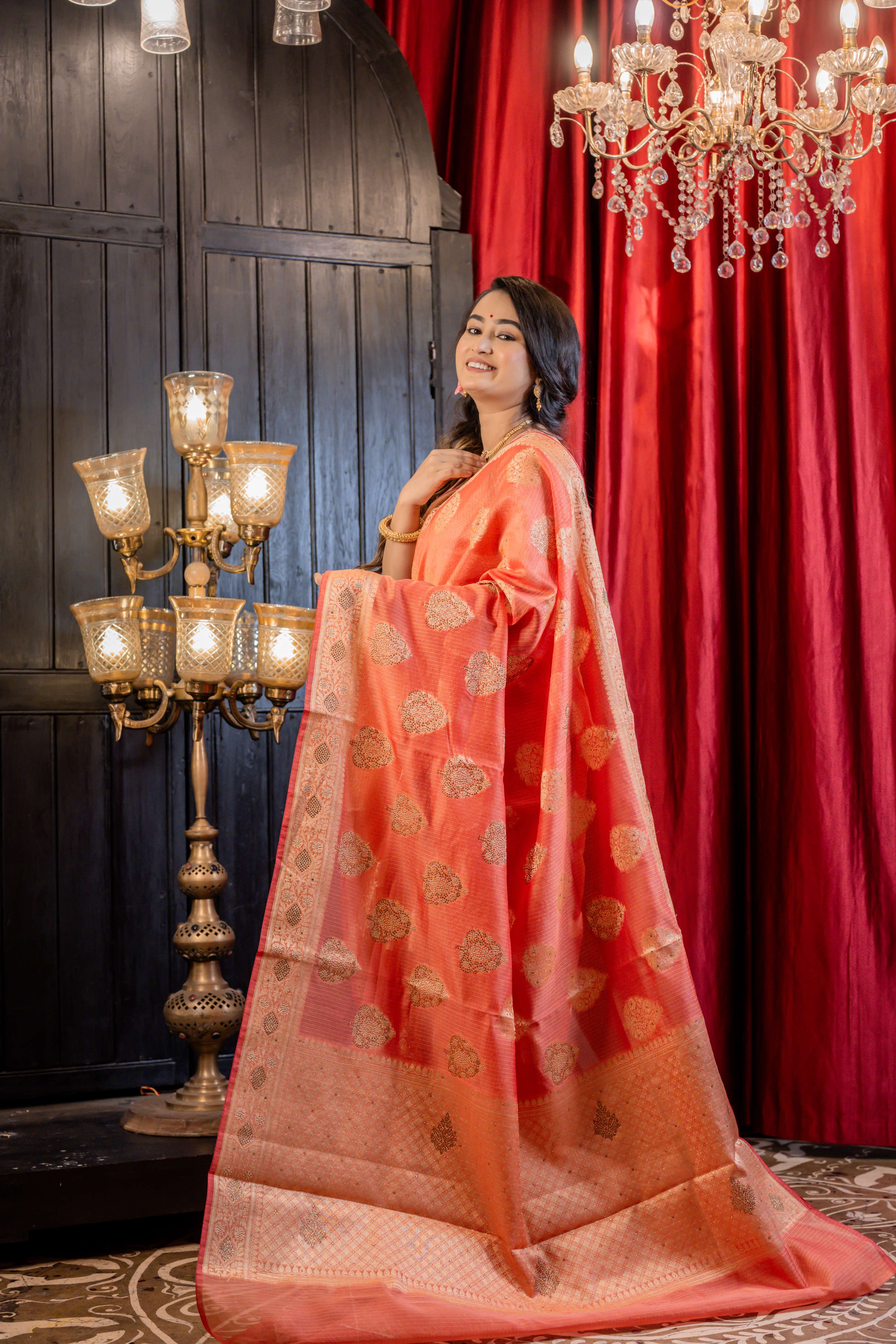 Ruchira || Brick Red Soft Silk Banarasi Saree with all over Matte Gold Zari Floral Buta, Brocade Pallu and Gold Rhinestone bead highlights