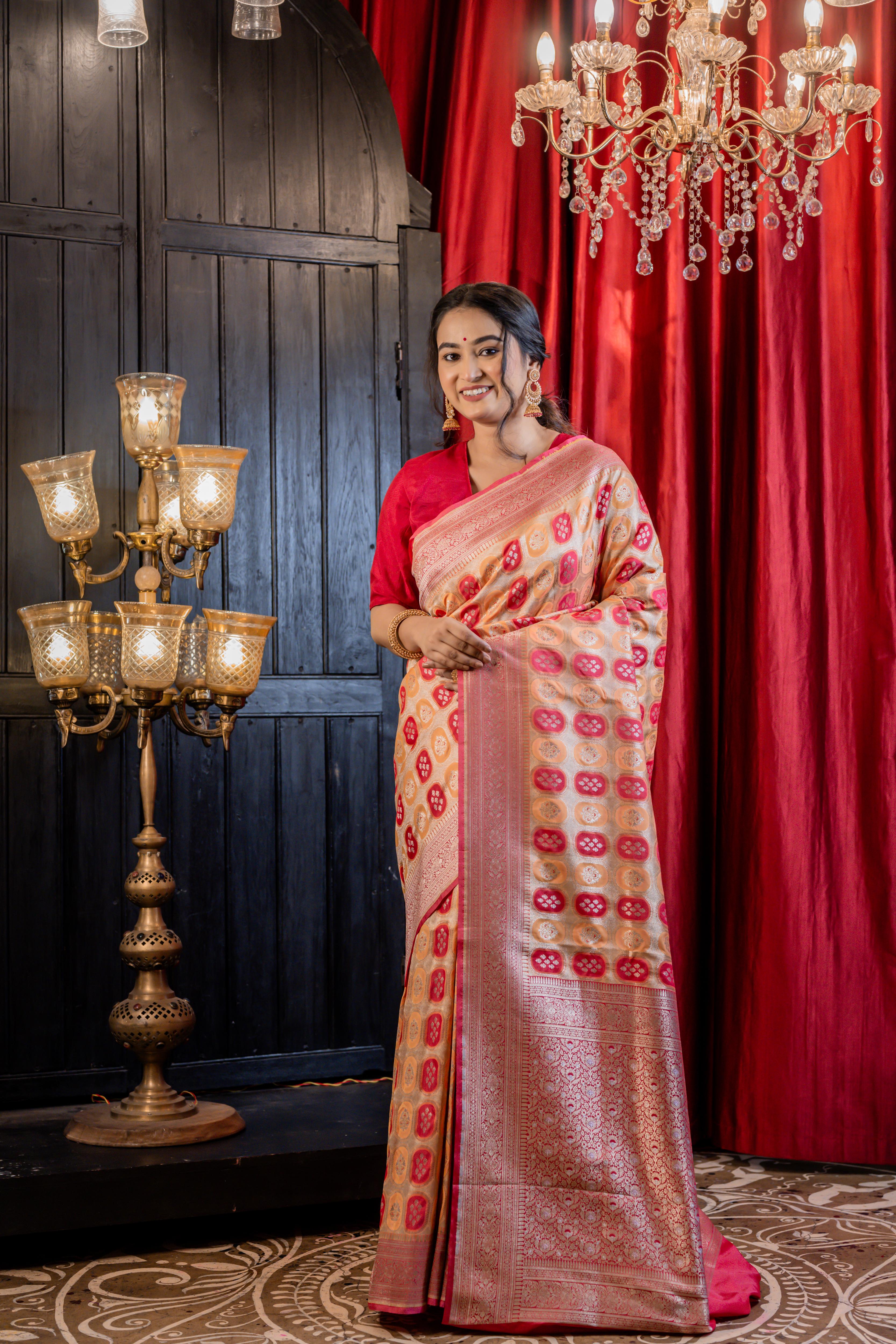 Abha || Woven Matte Gold Zari base Matka Silk Banarasi Saree with all over Peach & Raspberry Red Capsule shape Buta and Meenakari Floral highlights