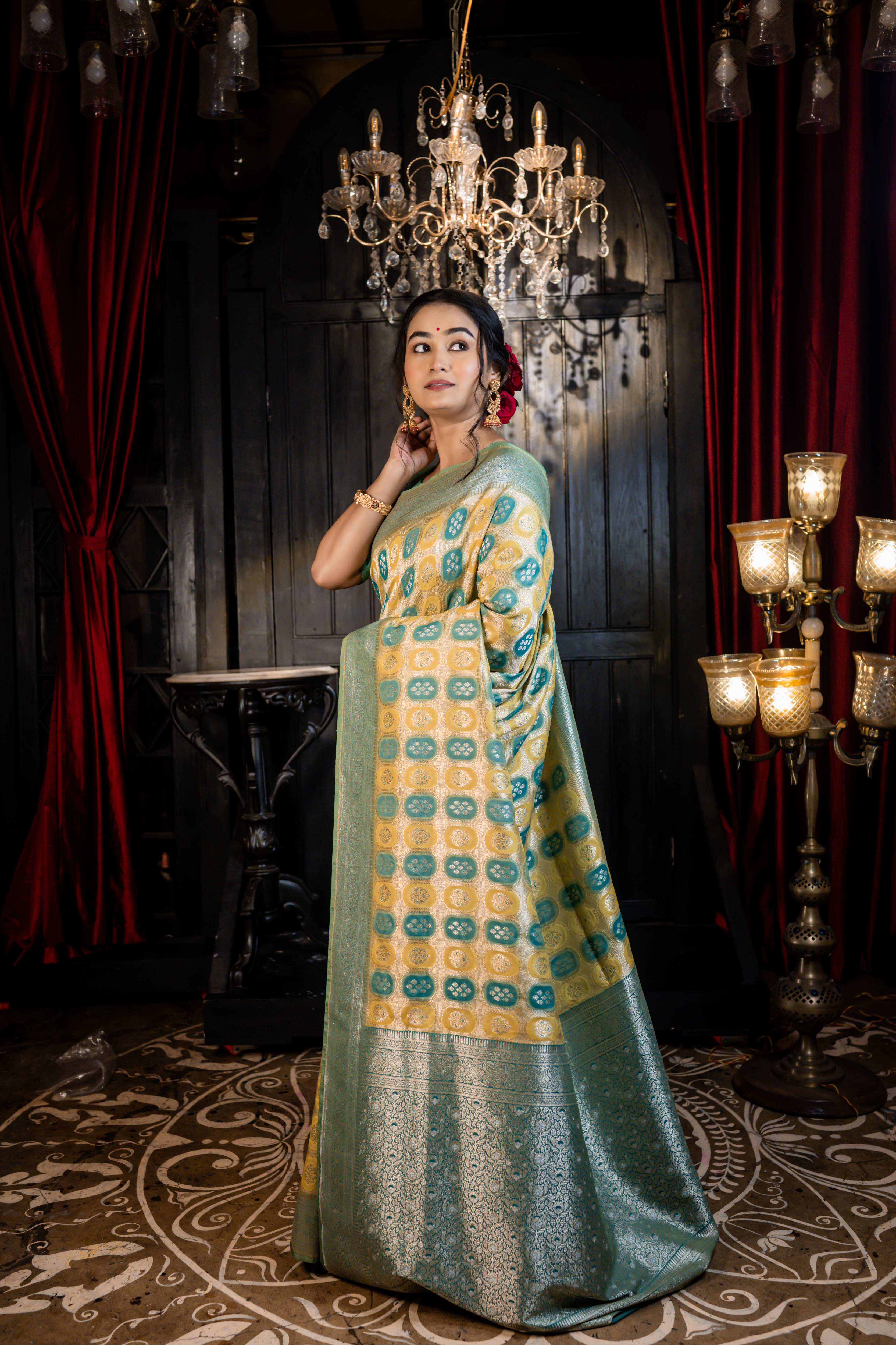 Vanaja || Woven Matte Gold Zari base Matka Silk Banarasi Saree with all over Teal & Olive Green Capsule shape Buta and Meenakari Floral highlights