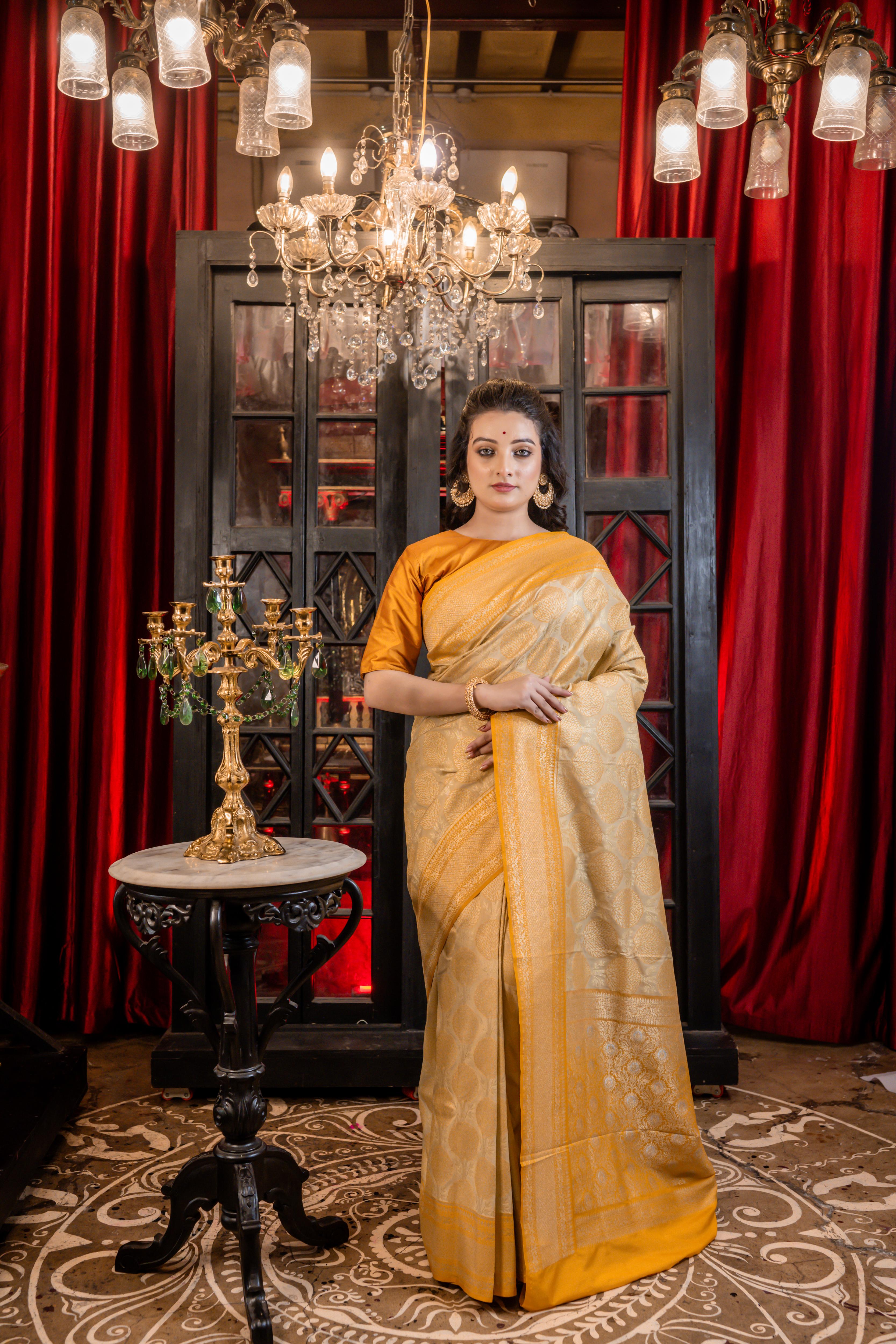 Varnika || Beige Base Matka Silk Banarasi Saree with Mango Yellow border and all over Tree motif woven in Matte Gold Zari