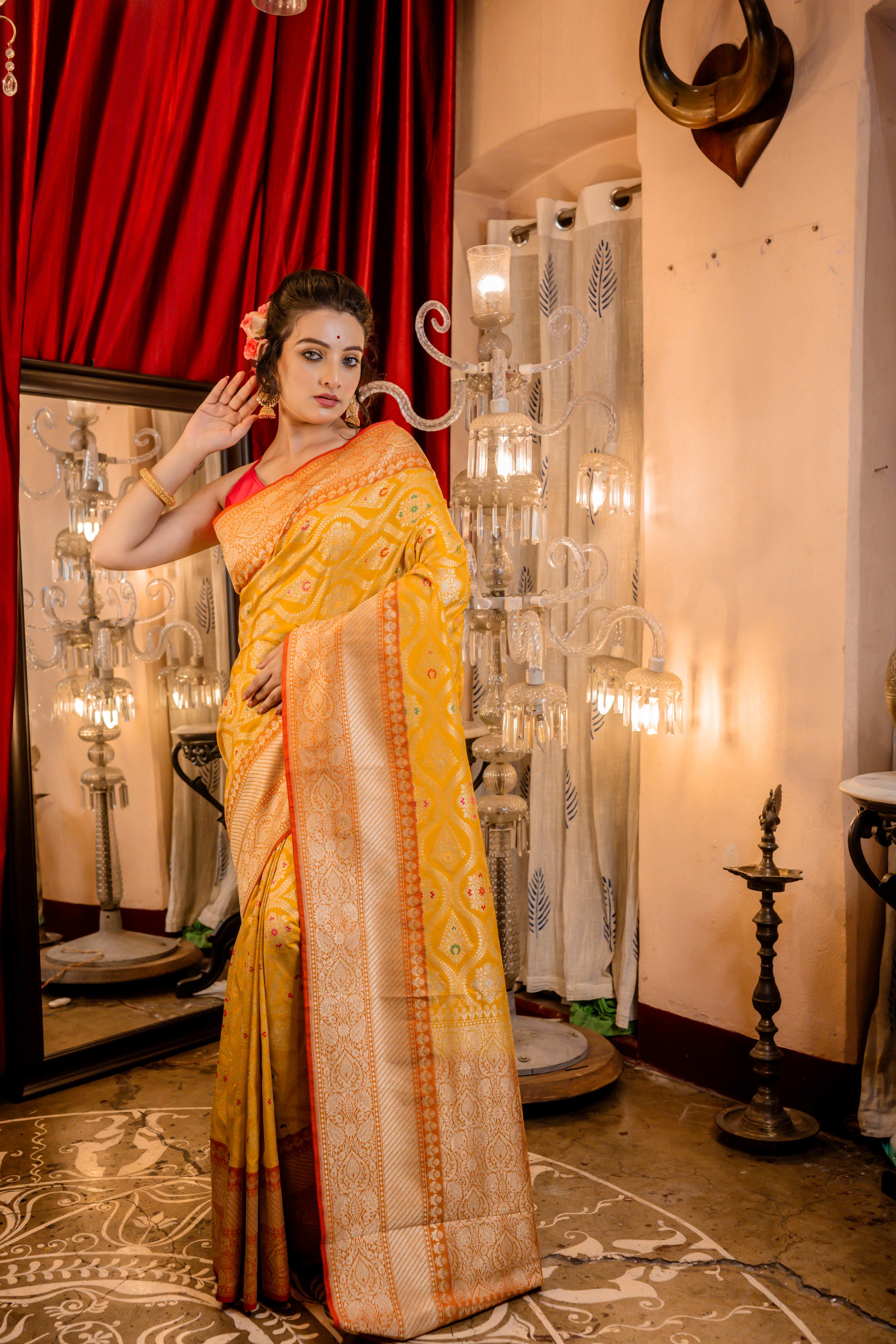 Ravina || Turmeric Yellow Matka Silk Banarasi Saree with Pale Orange border, all over Floral Jaal woven in Matte Gold Zari and multi-colour Meenakari highlights