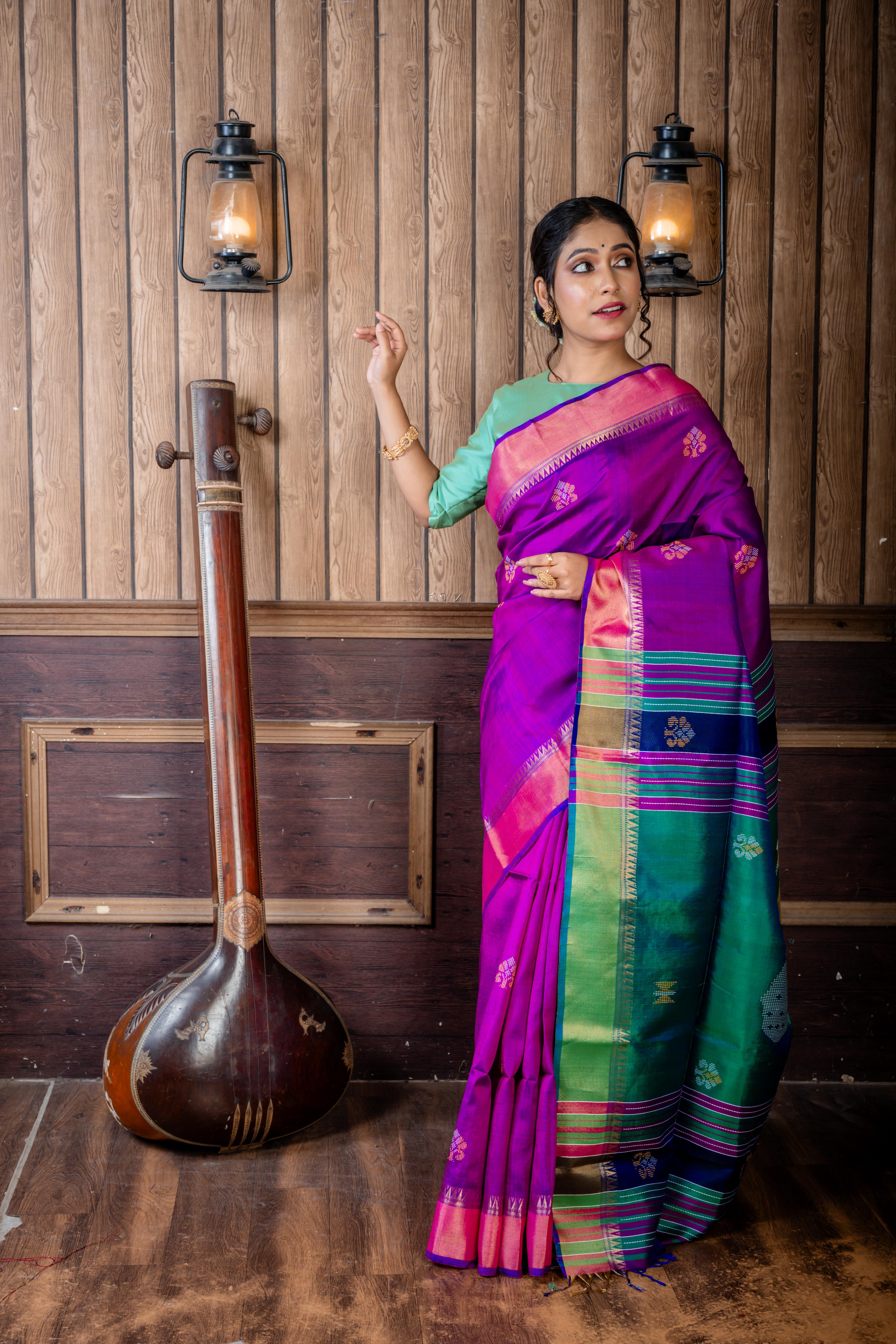 Pritha || Purple & Royal Blue dual tone Pure Bishnupuri Katan Handloom 'Kalakshetra' Embroidery Saree with all over Multi-colour Floral Buta and Stripe & 'Peacock' motif Green Pallu